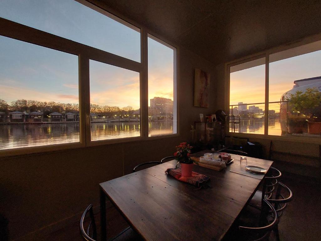 L'intérieur de la péniche Megalight II — la table du cabinet face à la Seine au coucher du soleil