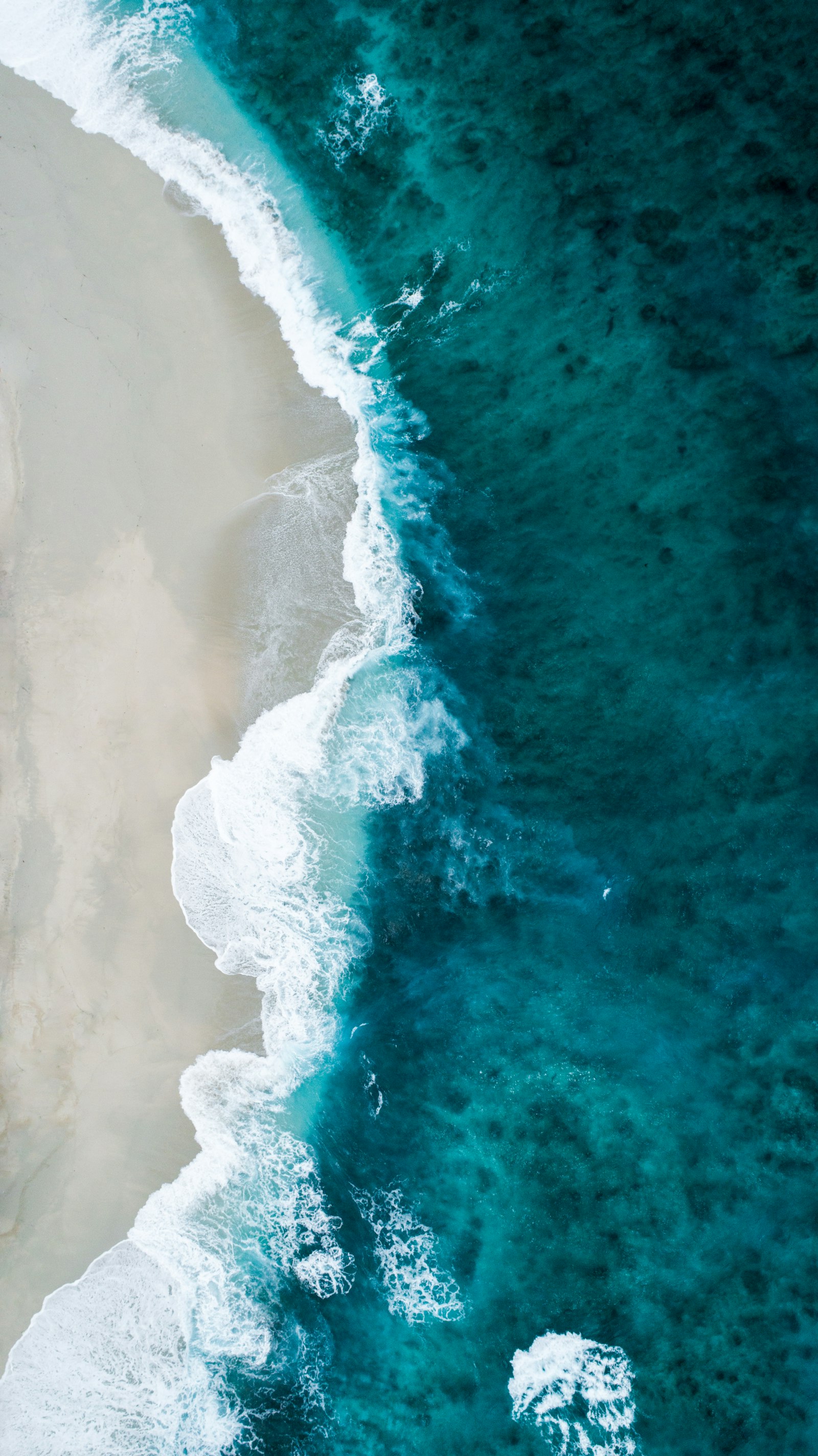 Vague venant caresser le sable, vue du ciel — eau calme et apaisante
